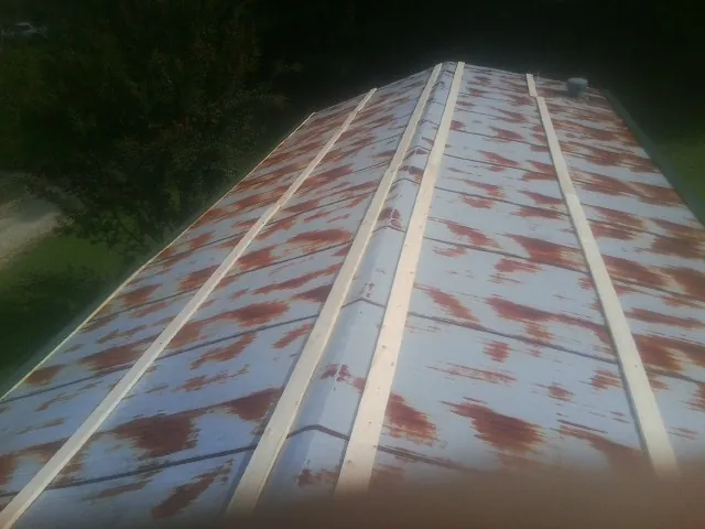 Rusted metal roof panels with new wood purlins before replacement — Storm Damage Roof Repair in Haledon by Roofing Brothers