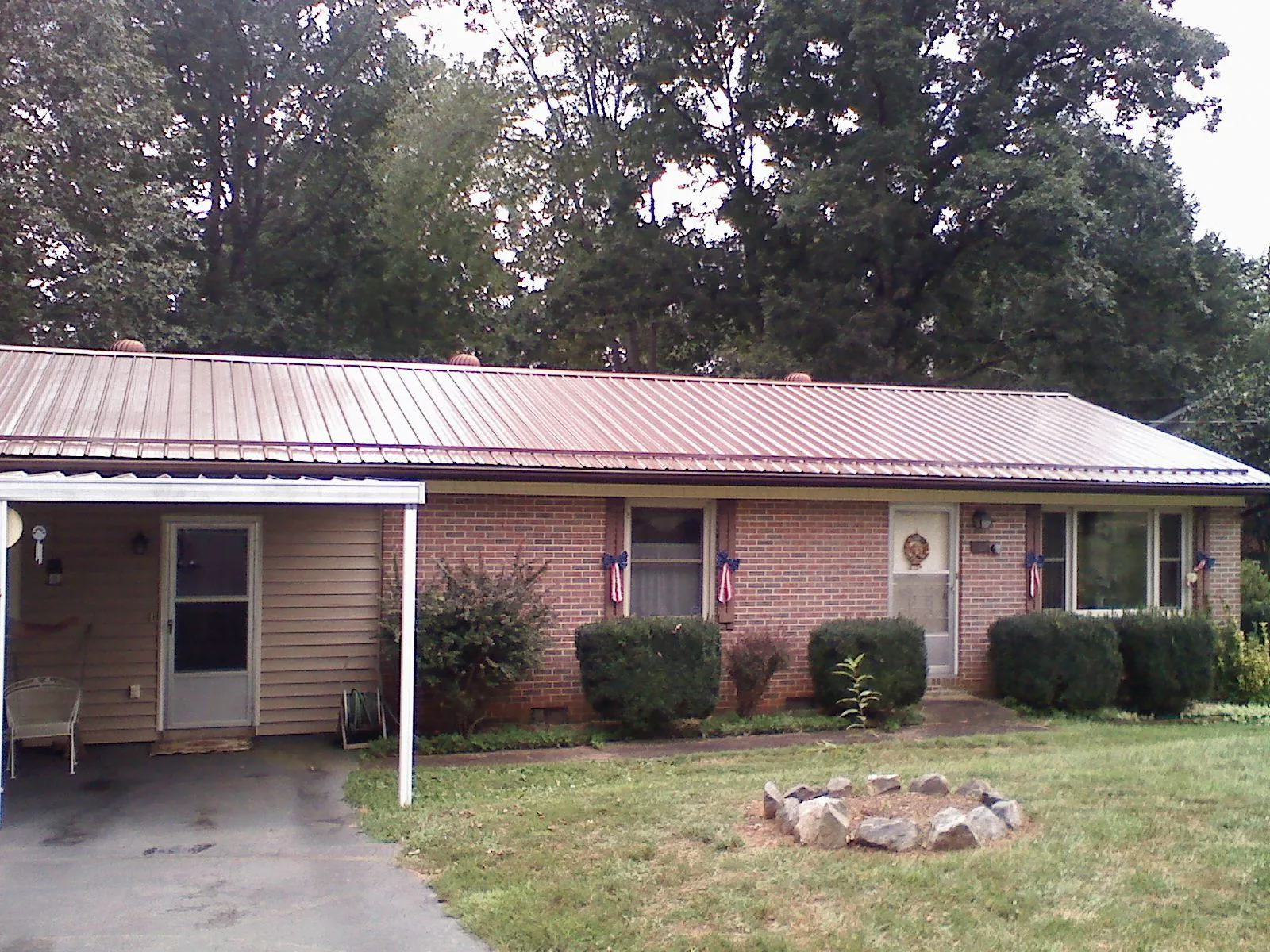 Bronze metal roof and carport on a brick ranch home — Roof Repair work by our crew in Haledon