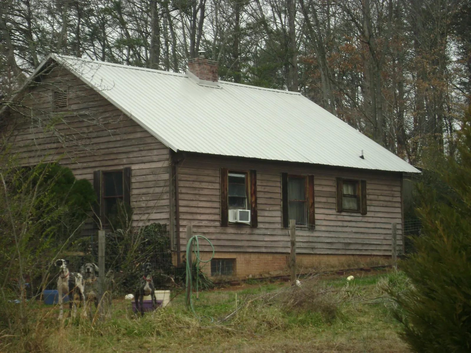 White metal roof on an old wood sided farmhouse, from a Metal Roof Installation job in Haledon